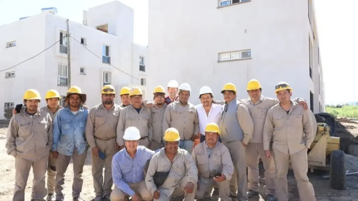 Equipo de trabajadores frente a un conjunto de viviendas en obra en el norte bonaerense