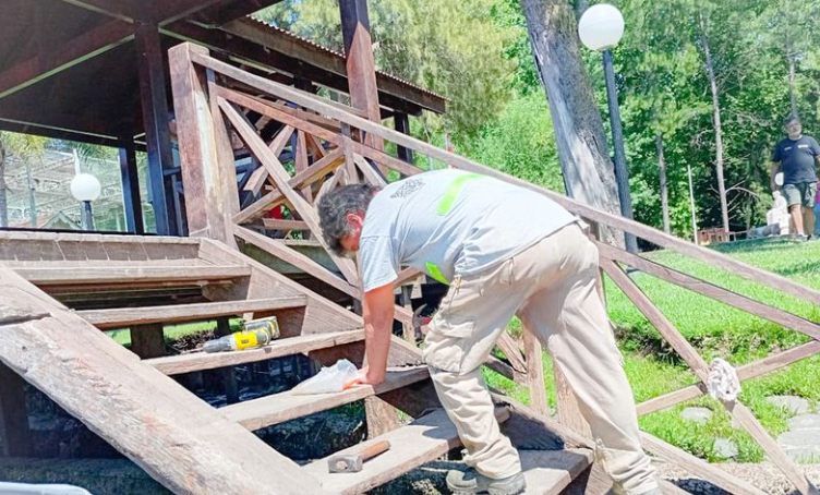 Trabajadores reparando una escalera de madera y un muelle en una propiedad del Delta del Tigre.