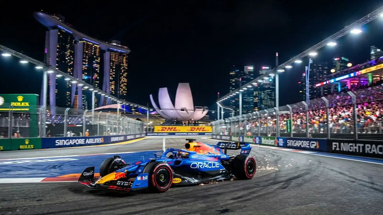 Monoplaza de Fórmula 1 compitiendo de noche en el circuito callejero de Marina Bay en Singapur