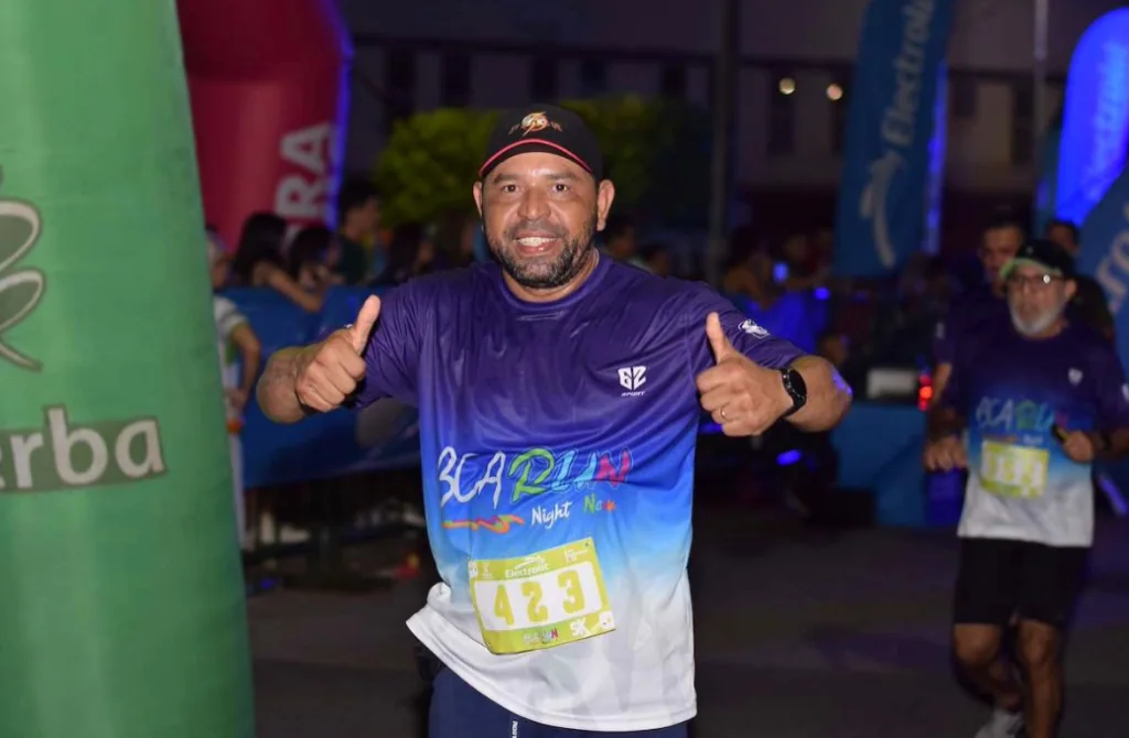 Corredor con dorsal 423 sonriendo con los pulgares arriba durante la competencia atlética nocturna Night Run Neon en Barrancabermeja
