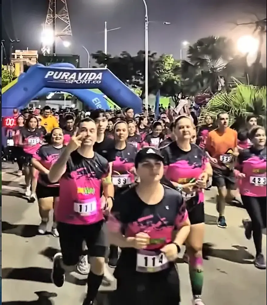 Pelotón de corredores en la largada nocturna iluminada