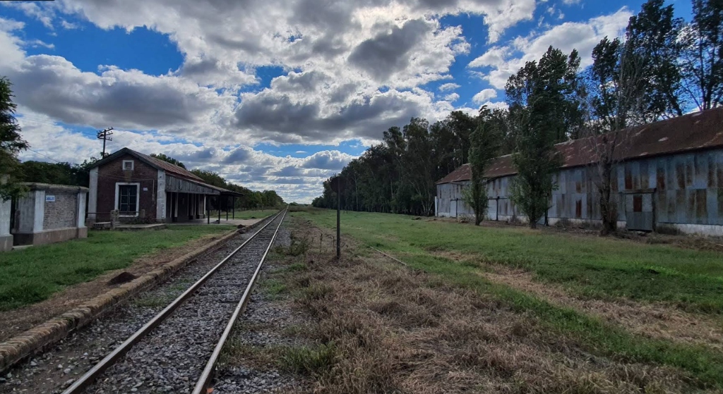 Fotografía de la estación de ferrocarril de Santa Coloma, rodeada de árboles y paisaje rural.